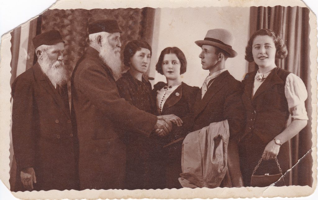 Family photo of men and women wearing nice clothing inside