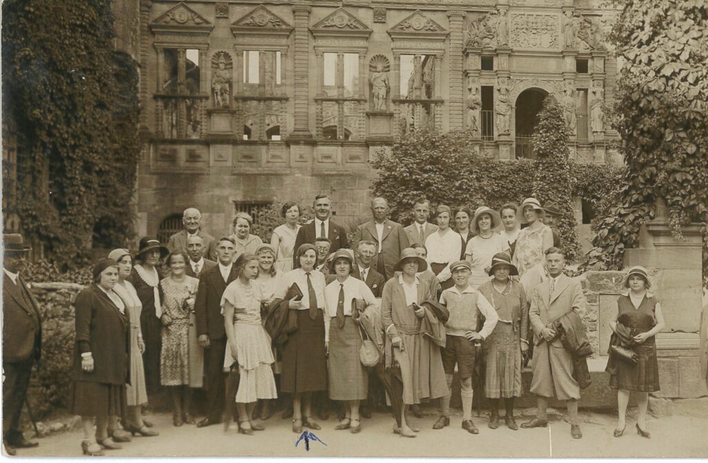 Group photo of men and women standing outside of building