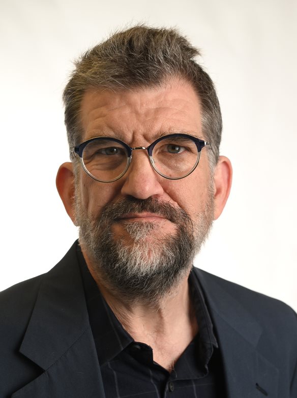 John Archibald wearing glasses and coat